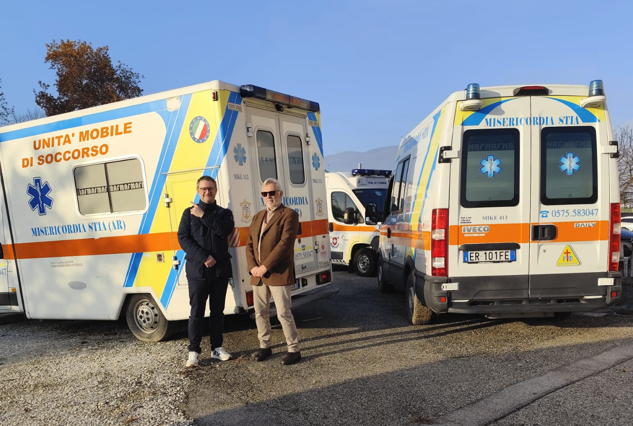 Edoardo from Lilea posing with another man in front of two donated ambulances