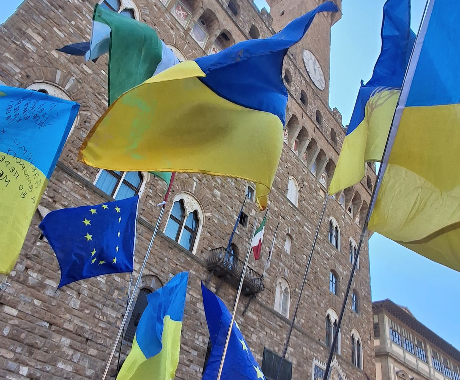Ukrainian flags and a European flag flying in front of Palazzo Vecchio, Florence