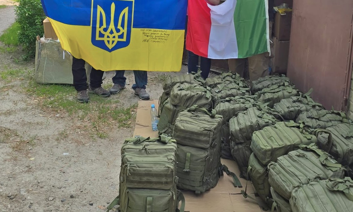 A lot of stashed medical backpacks, next to a Ukrainian and an Italian flag